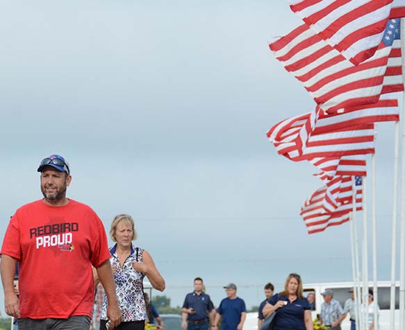 Farm Progress Show attendees walking next to american flags